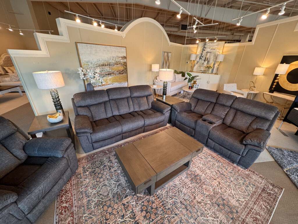 Reclining sofa and loveseat set at Cleo’s Furniture showroom.